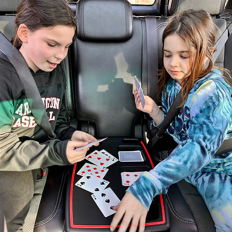 Children using a Stupid Car Tray as a surface for a card game